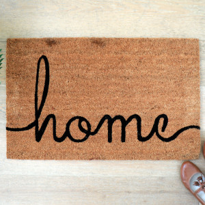Home Script coir doormat positioned at a wooden entrance