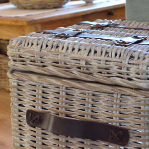 Close angled view of the greywashed rattan weave, leather straps and side handle
