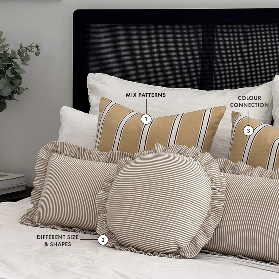 Neutral bedroom styling with layered striped cushions in varying sizes and shapes, illustrating how to mix patterns, balance proportions and create a cohesive colour palette.