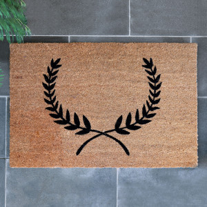 Large natural coir doormat with a black laurel wreath design at a home entrance