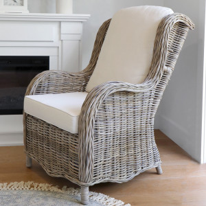 Side view of the curved Albany armchair beside a fireplace