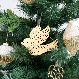 Gold peace dove ornament displayed on a green Christmas tree beside glittered gold glass baubles