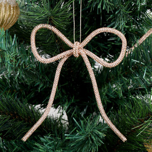 Champagne gold diamante bow with long tails hanging on a green Christmas tree