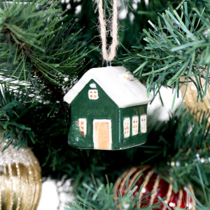 Holly Lane green bungalow bauble showing its front door and side windows among Christmas tree branches
