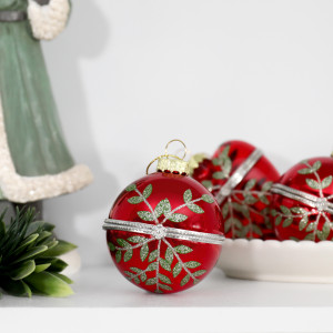 Rosalie round glass bauble styled with coordinating heart baubles, greenery and a green Santa ornament
