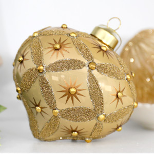 Close-up of Seraphina gold glass onion decoration with beaded diamond pattern, stars and raised gold accents