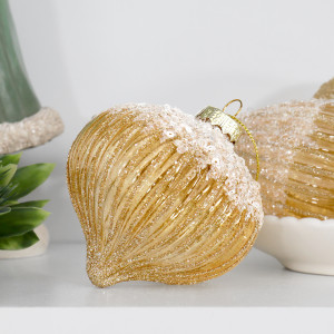 Francesca gold onion bauble displayed on a white shelf with greenery and other gold ornaments