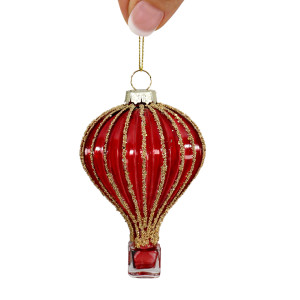 Jules red glass hot air balloon bauble held by its gold-coloured cord against a white background