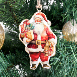Close-up of vintage-style metal Santa ornament carrying wrapped gifts and holly on a Christmas tree