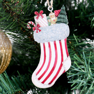 Vintage-style metal Christmas stocking decoration held by its twine loop against a white background