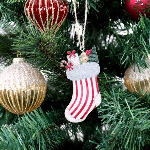 Red and white metal stocking decoration hanging amongst gold baubles and a red hot air balloon ornament