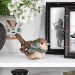 Mistletoe Bird Christmas decoration styled beside family photo frames and flowers on a white shelf