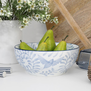Side view of the blue and white ceramic fruit bowl filled with green pears on a kitchen bench
