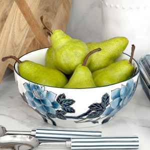 Blue and white serving bowl with blue flowers on a kitchen bench filled with fresh green pears