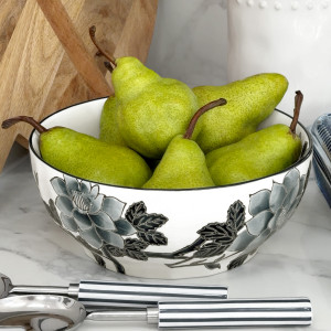 Black and white camellia ceramic bowl filled with green pears on a marble kitchen bench