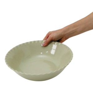 Maeve serving bowl tilted towards the camera to show its glossy speckled interior and scalloped rim