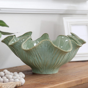 Close-up of Selena sea green display bowl on a timber console beside white beads and a white frame