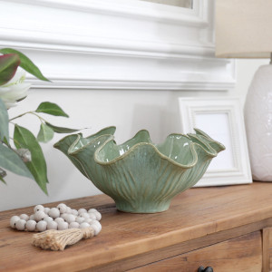 Selena sea green display bowl in a wider console setting with a white lamp, frame, beads and leafy stems