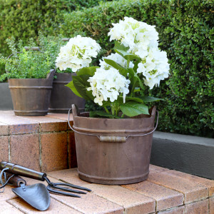 Hartwell Barrel Bucket with carry handle positioned on a garden step
