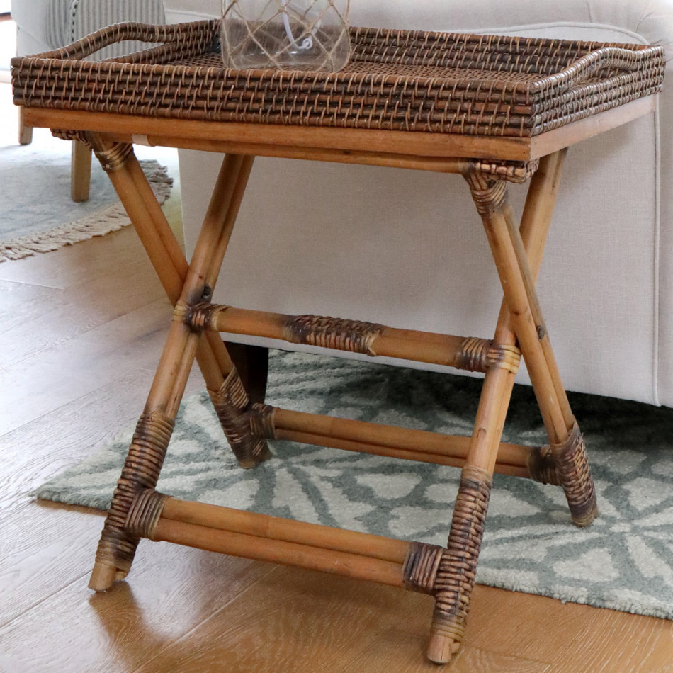 Brown rattan butler's tray table beside a neutral upholstered sofa