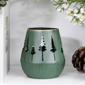 Close-up of green metal tealight holder with Christmas tree cut-outs and gold coloured edging