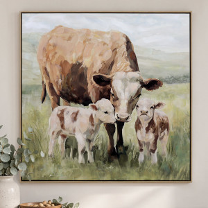 Framed cow and two calves canvas in soft brown and green tones, styled beside eucalyptus and a cream vase