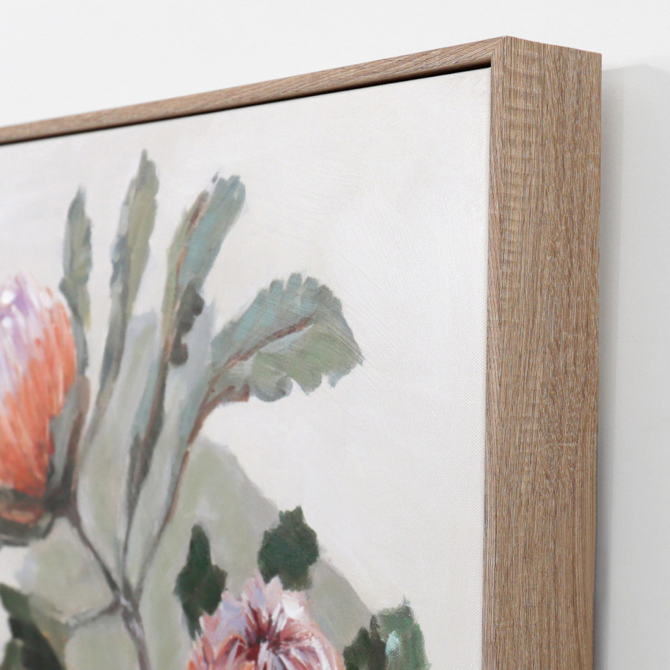 Angled close-up of the natural-coloured frame and canvas surface with banksia flowers and green leaves