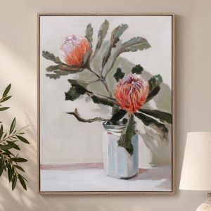 Framed banksia canvas with red-orange flowers and green foliage in a pale jar, styled beside a lamp