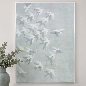 White-framed bird canvas with pale blue-green tones, styled beside eucalyptus in a glazed vase