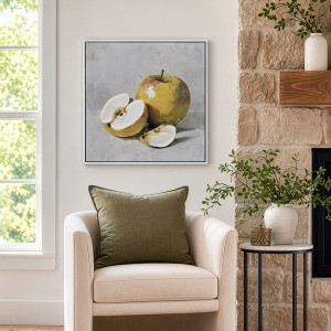 Golden apple canvas above a cream armchair with an olive cushion, beside a window and stone fireplace