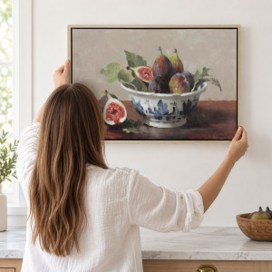 Person positioning the Lombard fig still life above a kitchen bench beside a window