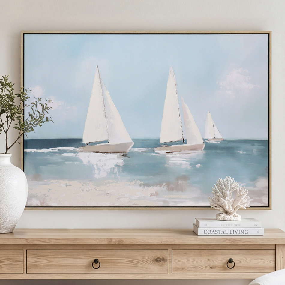 Framed blue-and-white yacht canvas above a timber console, styled with a white vase and coral ornament