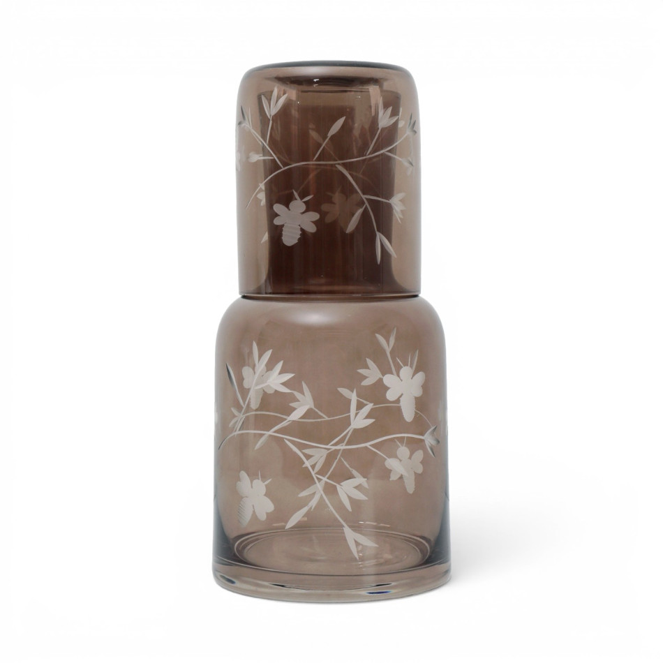 Chestnut-brown botanical and bee etched tumbler stored upside down on the matching glass carafe