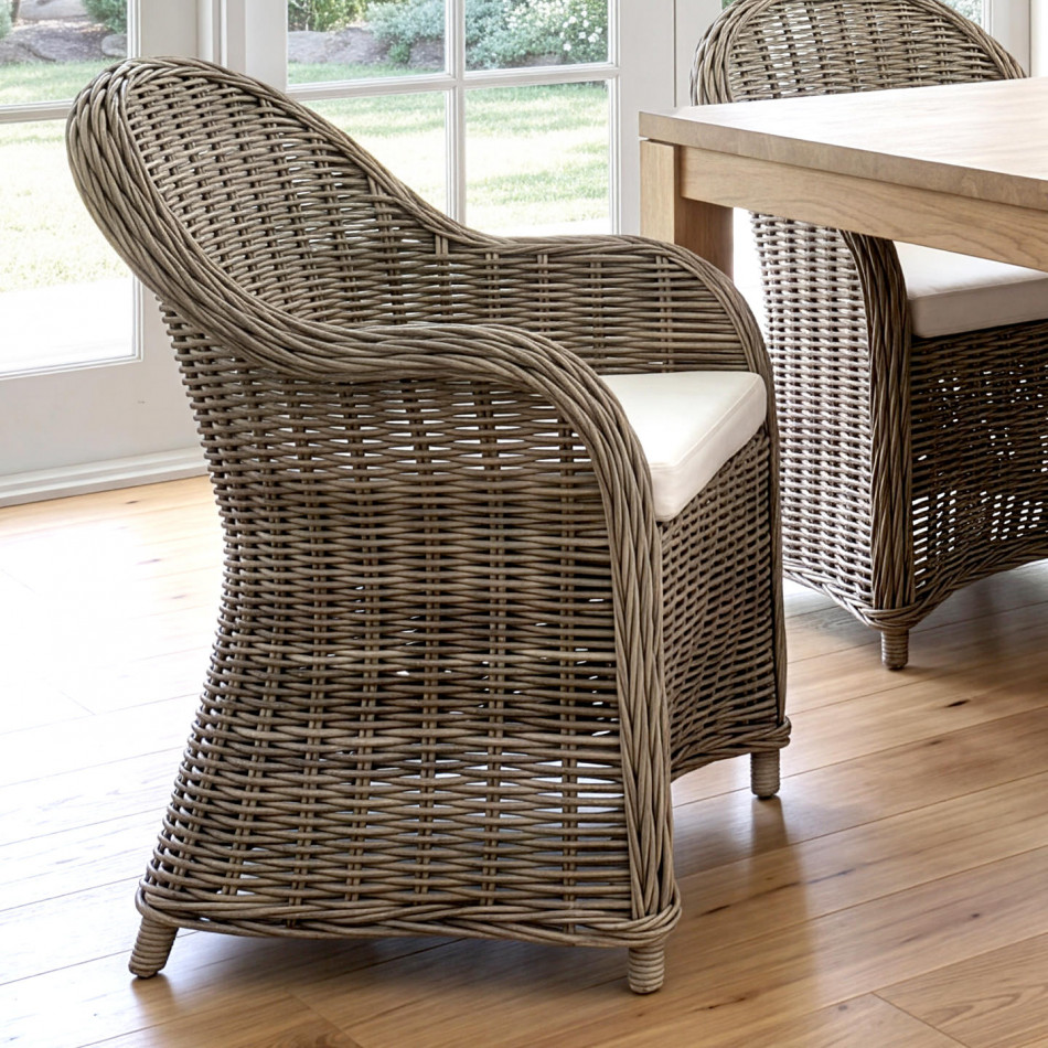 Side view of an Ashford rattan dining chair positioned beside a wood dining table
