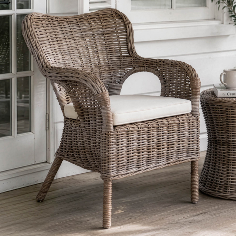 Calypso grey-brown rattan armchair with cream cushion on a covered verandah