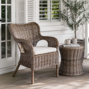 Calypso rattan armchair styled beside a matching round table on a verandah