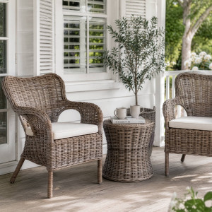 Two Calypso rattan armchairs arranged around a round side table outdoors undercover