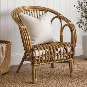 Avery honey-brown rattan armchair with a cream cushion in a neutral living room