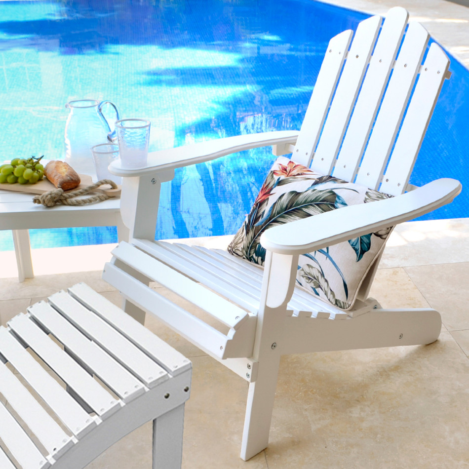 White Adirondack chair and matching slatted footrest styled beside a blue swimming pool