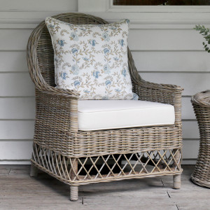 Oxford rattan armchair styled with a blue floral cushion against grey cladding