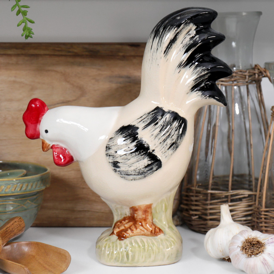 Hand painted cream ceramic rooster ornament with black feathers and red comb displayed in a country kitchen.
