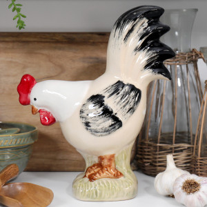 Hand painted cream ceramic rooster ornament with black feathers and red comb displayed in a country kitchen.