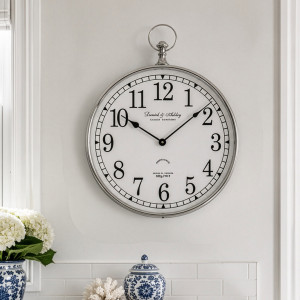 Stanford Silver Fob Wall Clock displayed above blue and white ceramics