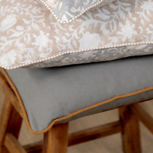 Jane Grey Cushion with Terracotta Piping, shown as a soft decorative accent for layering on seating or a bed