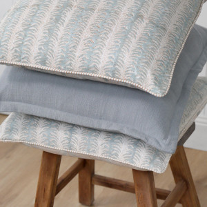 Palmetto Reversible Coastal Blue Cushion, shown as a soft decorative accent for layering on seating or a bed