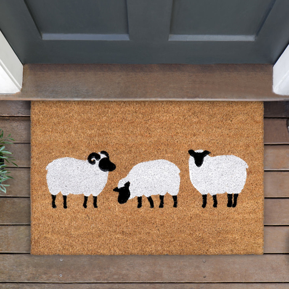 Dundee sheep coir doormat with three black-faced white sheep on timber boards at a dark front door