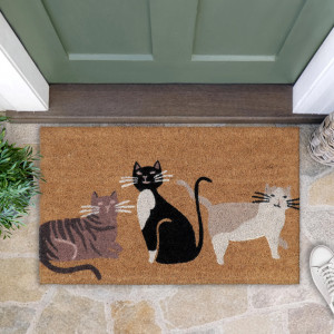 Three-cat coir doormat at a green door, styled with greenery, a woven basket and a white shoe