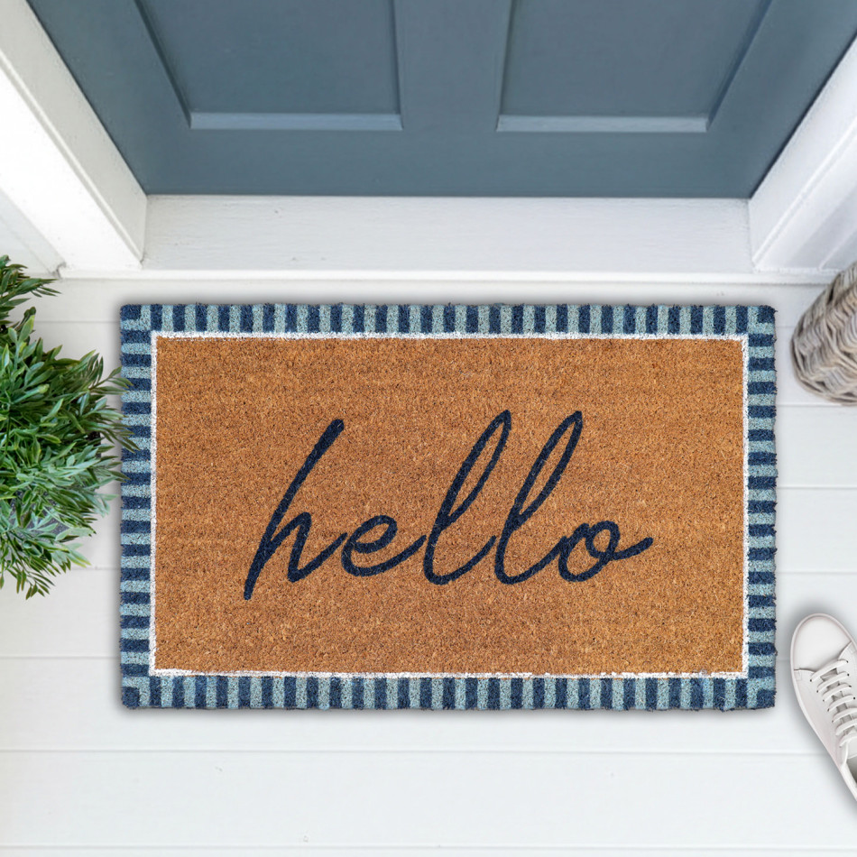 Hello doormat with navy and pale blue stripes styled on a white porch with greenery and white shoes