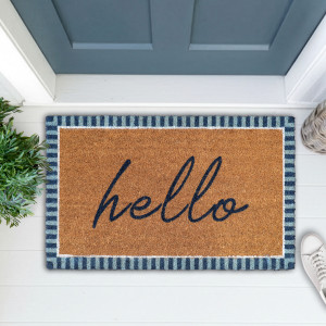 Hello doormat with navy and pale blue stripes styled on a white porch with greenery and white shoes