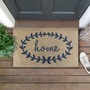 Thick natural coir doormat styled at a doorway with a steel-grey laurel wreath